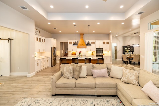 living room featuring a barn door and light hardwood / wood-style flooring