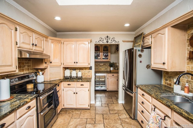 kitchen with appliances with stainless steel finishes, sink, beverage cooler, and light brown cabinetry