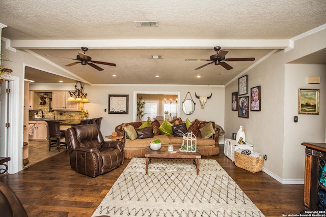 living room featuring dark wood-type flooring, a textured ceiling, ornamental molding, ceiling fan, and beam ceiling