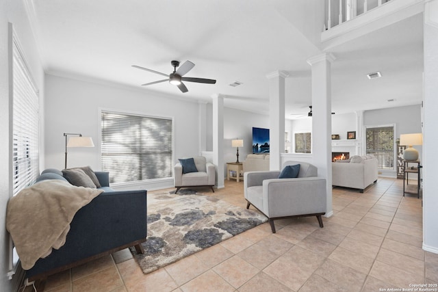 tiled living room with crown molding, ceiling fan, and ornate columns