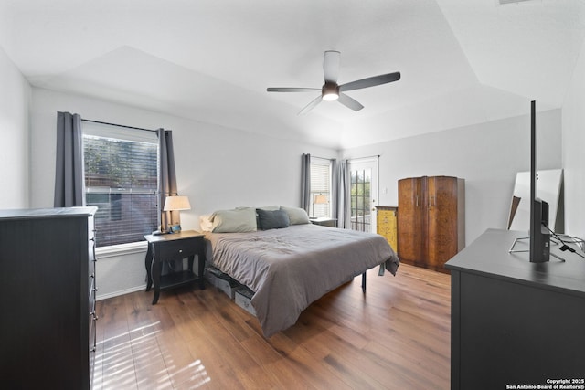 bedroom featuring ceiling fan, a tray ceiling, and dark hardwood / wood-style flooring