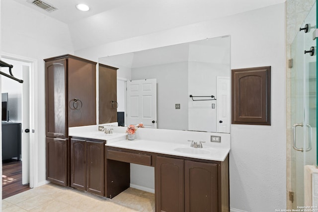 bathroom featuring tile patterned flooring, vanity, and a shower with shower door