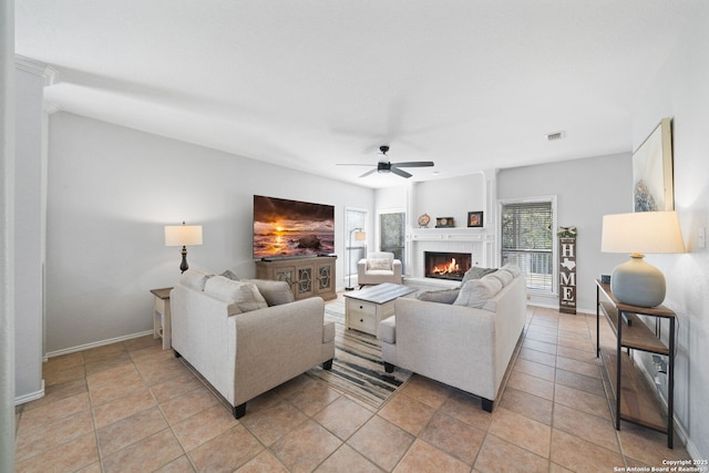 tiled living room with ceiling fan and a brick fireplace