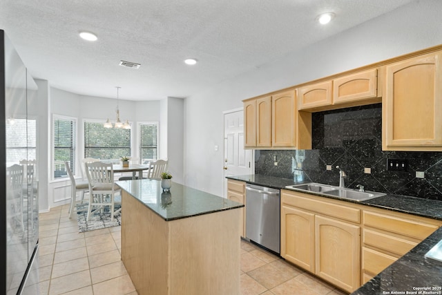 kitchen with light brown cabinetry, tasteful backsplash, sink, hanging light fixtures, and stainless steel dishwasher