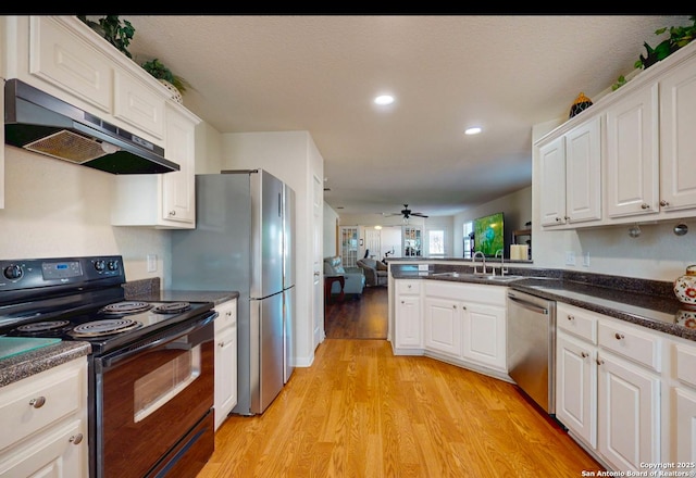 kitchen with white cabinetry, appliances with stainless steel finishes, light hardwood / wood-style floors, and kitchen peninsula