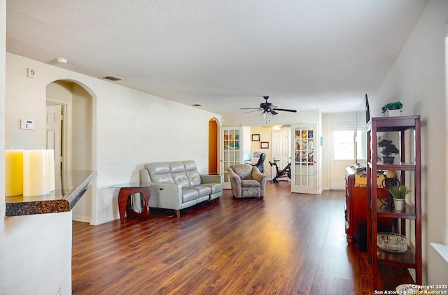 living room featuring dark hardwood / wood-style floors, ceiling fan, and french doors