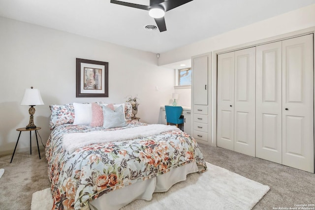 bedroom featuring light colored carpet, ceiling fan, and a closet