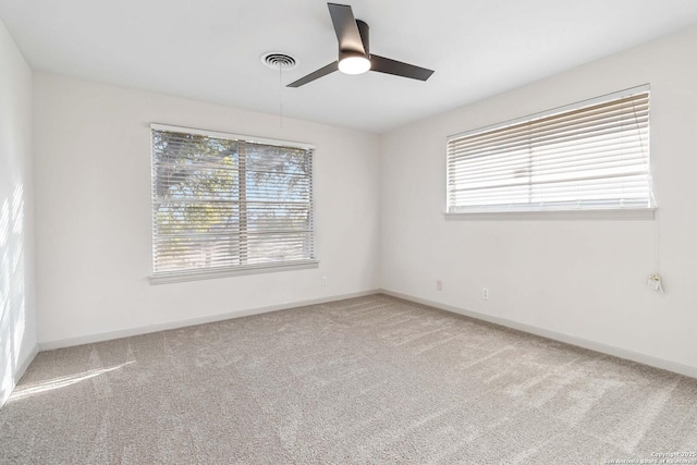 carpeted empty room with ceiling fan and a healthy amount of sunlight