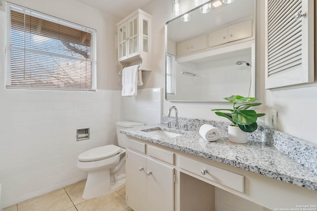 bathroom featuring vanity, a healthy amount of sunlight, tile walls, and tile patterned floors