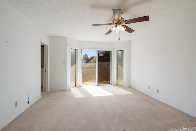 carpeted empty room with ceiling fan and a textured ceiling