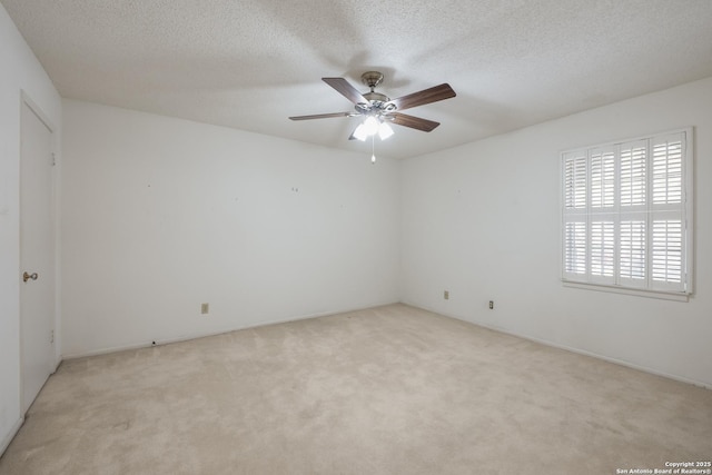 carpeted spare room featuring ceiling fan and a textured ceiling