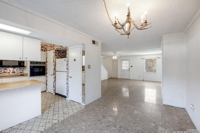 kitchen featuring ceiling fan with notable chandelier, white cabinets, a textured ceiling, and black appliances