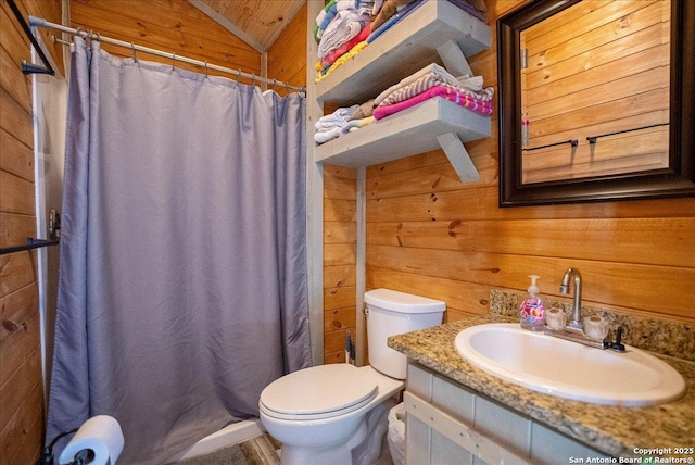 bathroom with wooden walls, lofted ceiling, vanity, toilet, and a shower with shower curtain