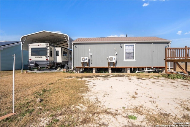 rear view of property featuring a carport and a yard