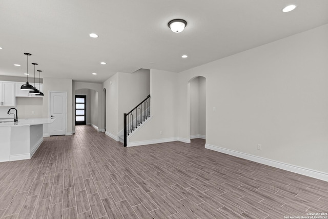 unfurnished living room featuring sink and light hardwood / wood-style flooring