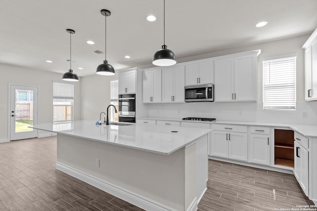 kitchen featuring white cabinetry, appliances with stainless steel finishes, and pendant lighting