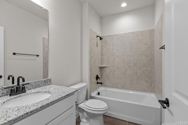 full bathroom featuring vanity, toilet, tiled shower / bath combo, and hardwood / wood-style floors