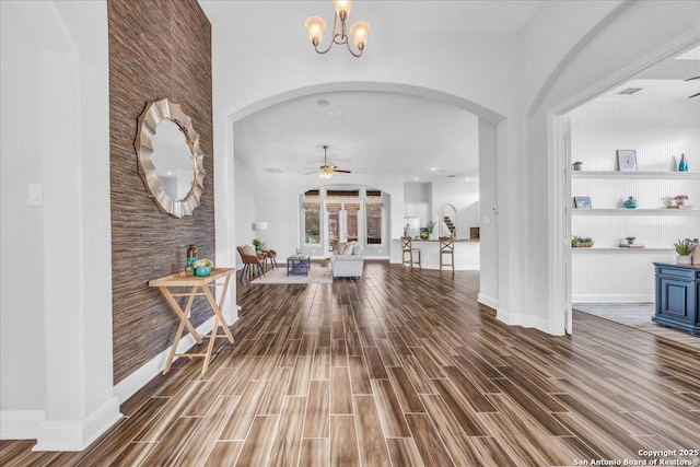 entryway with ceiling fan with notable chandelier