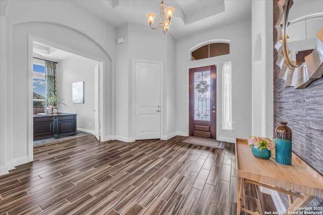 entryway with an inviting chandelier and a tray ceiling