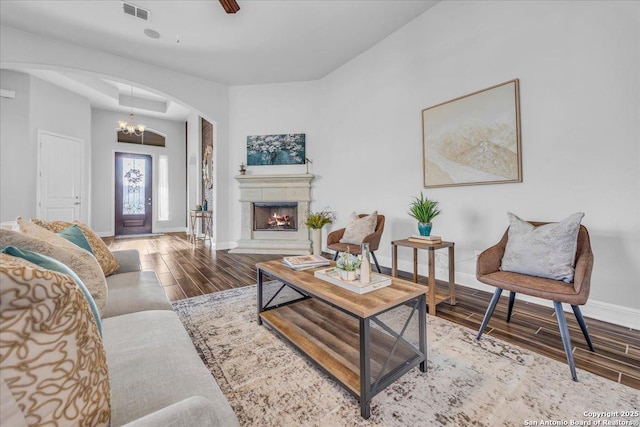 living room with hardwood / wood-style flooring and ceiling fan with notable chandelier