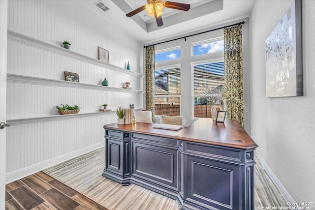 office featuring ceiling fan and a raised ceiling