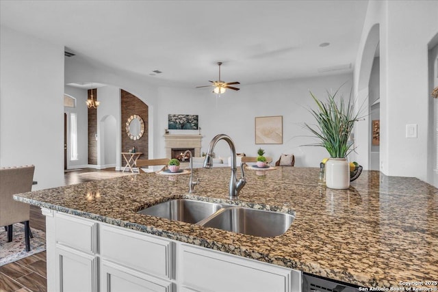 kitchen featuring dark hardwood / wood-style floors, white cabinetry, sink, dark stone countertops, and ceiling fan