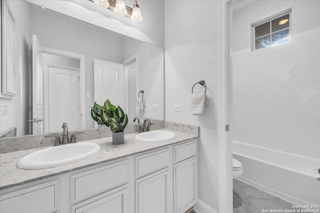 full bathroom featuring tiled shower / bath, vanity, and toilet