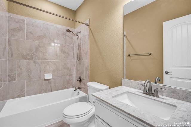 full bathroom featuring vanity, toilet, and tiled shower / bath