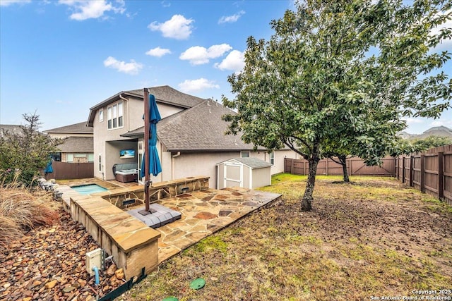 rear view of house with a pool, a patio, and a storage unit