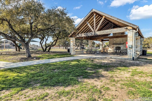 view of yard featuring a gazebo and an outdoor stone fireplace