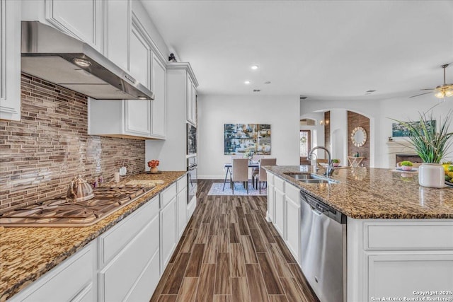 kitchen with sink, white cabinetry, tasteful backsplash, dark stone counters, and stainless steel appliances