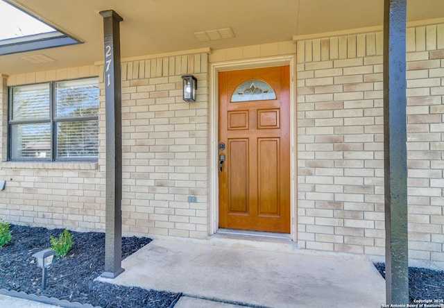 property entrance featuring brick siding