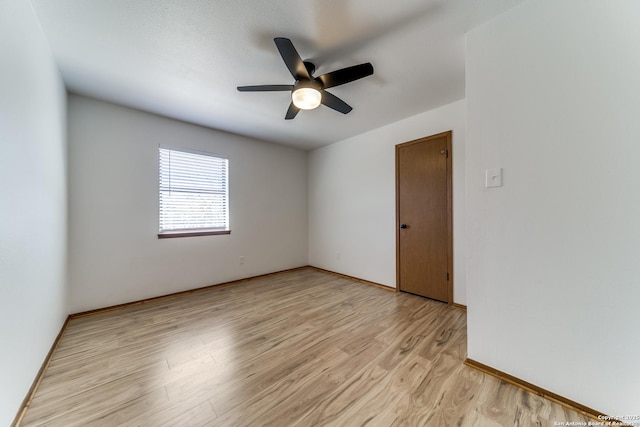 unfurnished room featuring baseboards, light wood-style floors, and a ceiling fan