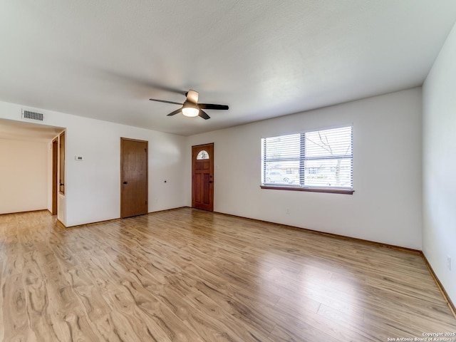 unfurnished living room featuring light wood finished floors, visible vents, baseboards, and ceiling fan