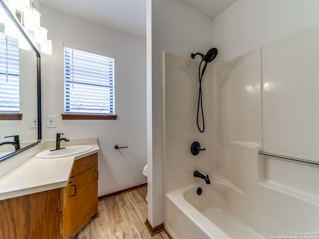 full bathroom featuring vanity, toilet, wood finished floors, and a wealth of natural light