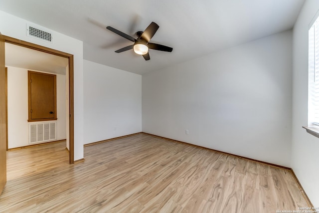 empty room with visible vents, a ceiling fan, and light wood-style floors