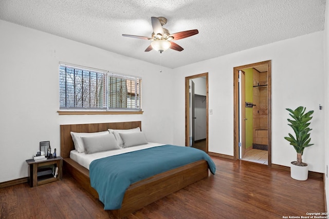 bedroom with dark wood-type flooring, ensuite bathroom, a spacious closet, a textured ceiling, and ceiling fan