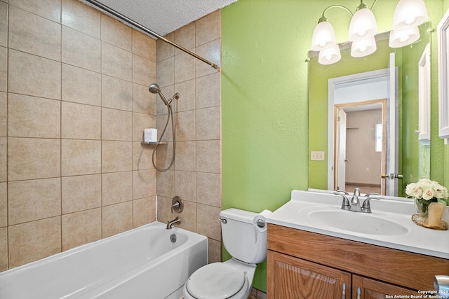 full bathroom featuring vanity, toilet, tiled shower / bath combo, and a textured ceiling