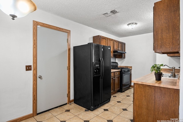 kitchen with sink, black appliances, and a textured ceiling