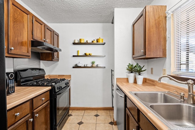 kitchen featuring light tile patterned flooring, sink, a textured ceiling, black gas range oven, and stainless steel dishwasher