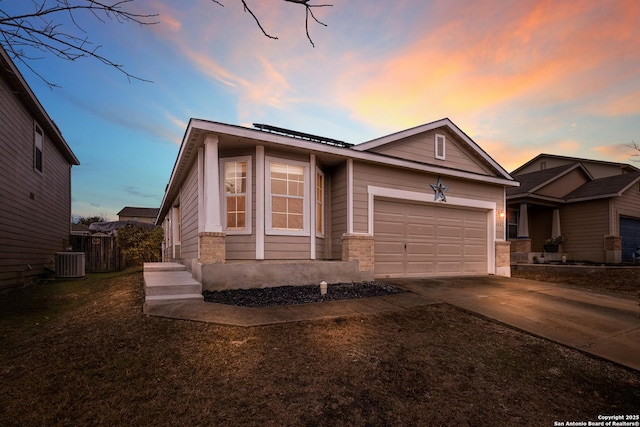 view of front of property featuring central AC and a garage