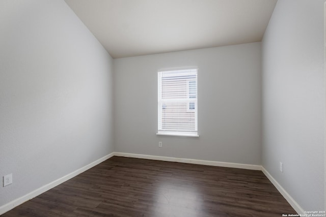 empty room featuring dark wood-type flooring and baseboards