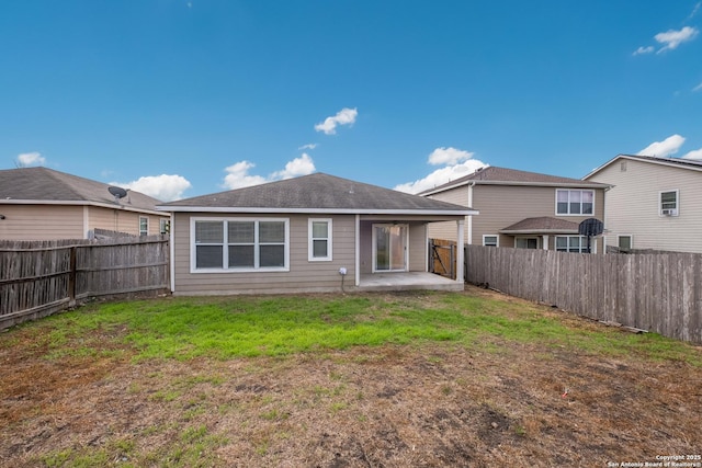 rear view of property with a lawn, a fenced backyard, and a patio area