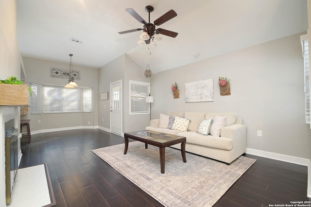 living room with a high end fireplace, dark wood-type flooring, ceiling fan, and vaulted ceiling