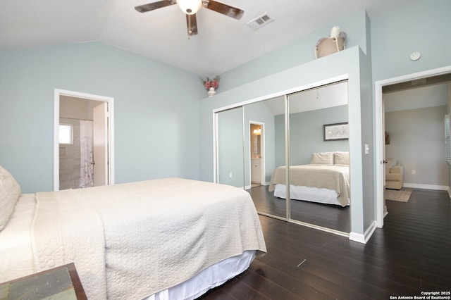 bedroom with lofted ceiling, ensuite bath, dark wood-type flooring, ceiling fan, and a closet