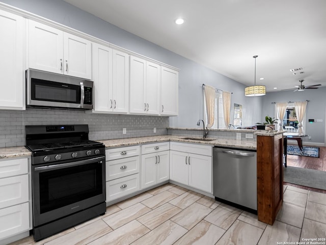 kitchen with stainless steel appliances, sink, and white cabinets