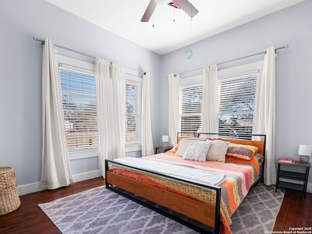 bedroom with multiple windows, dark wood-type flooring, and ceiling fan