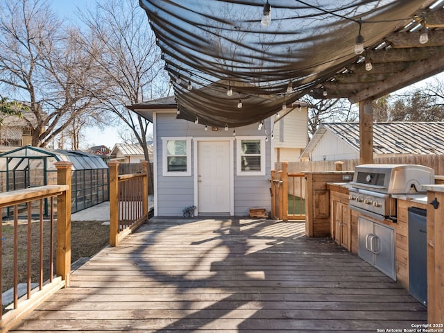 wooden terrace with an outdoor structure, area for grilling, and grilling area