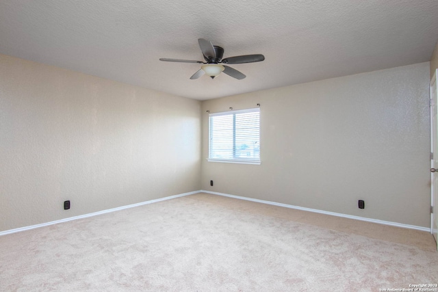 spare room with ceiling fan, light carpet, and a textured ceiling