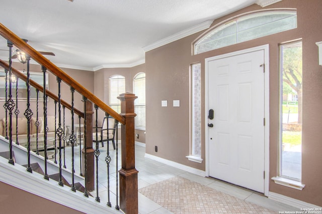 tiled foyer with ornamental molding and plenty of natural light